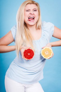 Kırmızı ve yeşil greyfurt tutan kadın