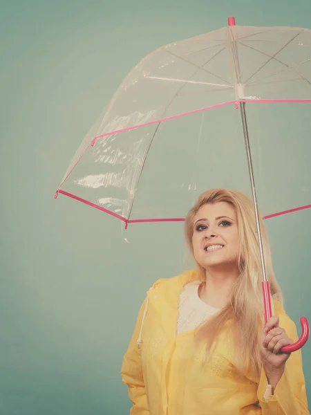Щаслива жінка в плащі тримає прозору парасольку — стокове фото