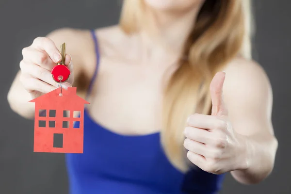 Mujer sosteniendo la llave con símbolo de la casa — Foto de Stock