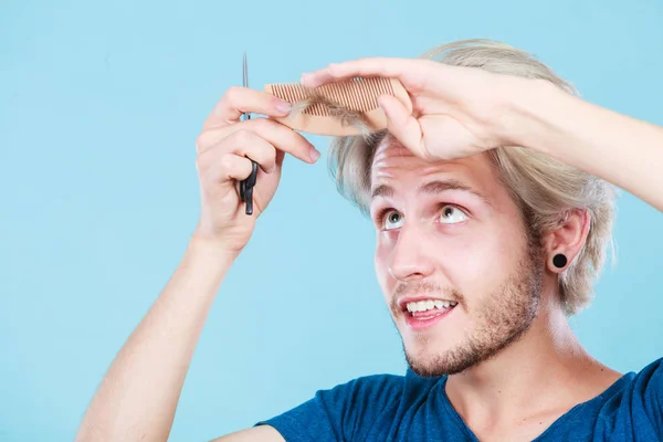 Hombre con tijeras y peine creando nuevo peine — Foto de Stock