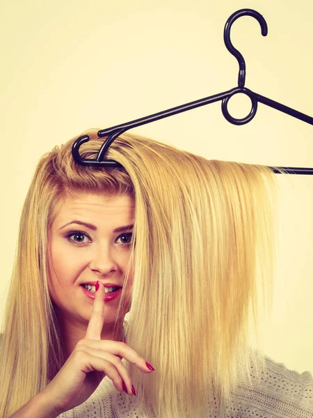Mulher segurando o cabelo no cabide de roupas — Fotografia de Stock