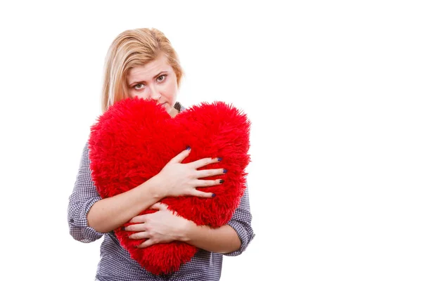 Trauriges Mädchen hält großes rotes Kissen in Herzform — Stockfoto