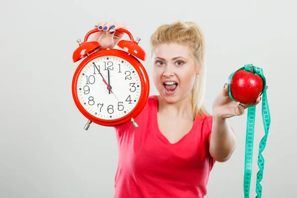 Gelukkige vrouw bedrijf klok, apple en meetlint — Stockfoto