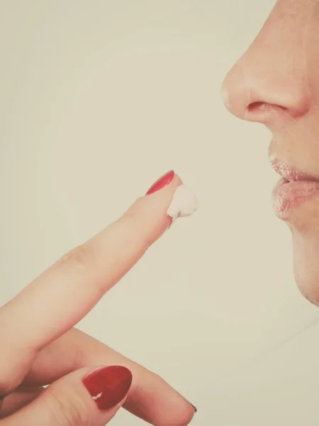 Woman applies lip balm cream to her lips — Stock Photo, Image