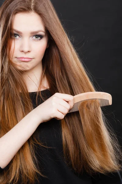 Длинноволосая женщина расчесывает волосы . — стоковое фото