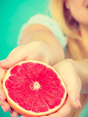 İnsan elinde kırmızı greyfurt narenciye meyve yarısı