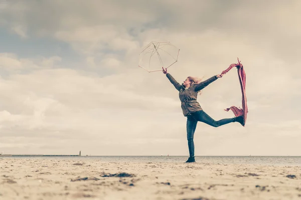 Glückliche Frau springt mit Schal am Strand — Stockfoto