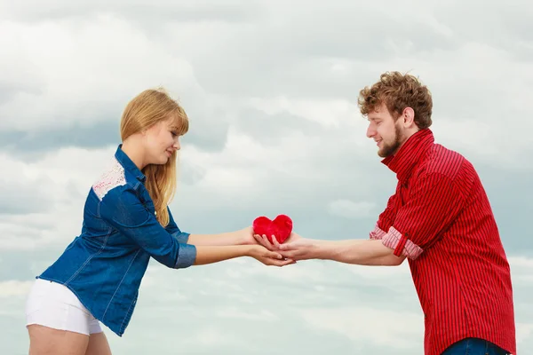 Пара закохана тримає червоне серце на відкритому повітрі — стокове фото
