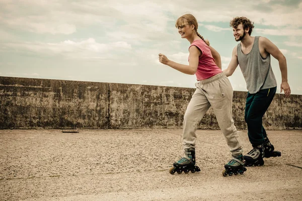 Dos personas corren juntas montando patines . —  Fotos de Stock