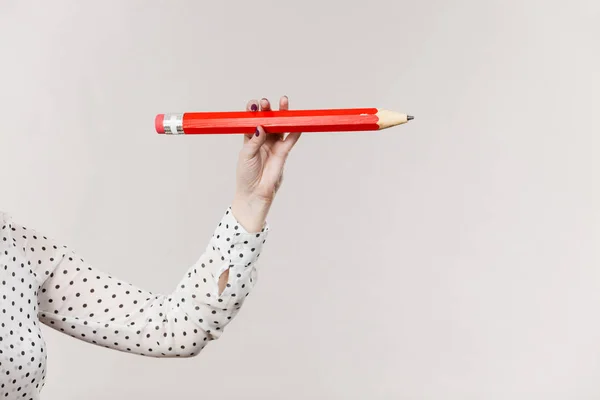 Женская рука держит большой красный карандаш — стоковое фото