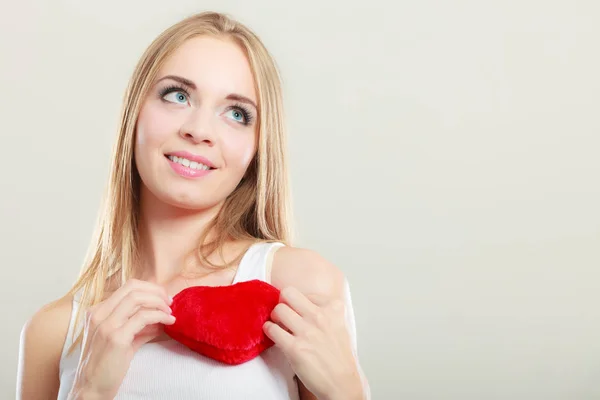 Mujer sonriente sosteniendo el símbolo de amor corazón rojo — Foto de Stock