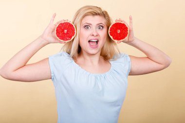 Kırmızı greyfurt tutan mutlu gülümseyen kadın