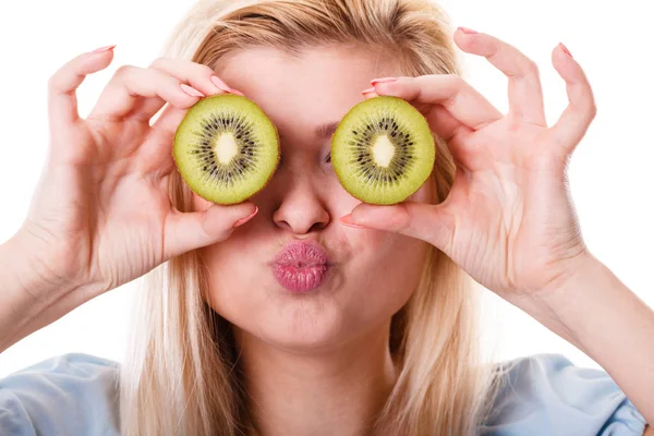 Woman holding green kiwi fruit like eyeglasses — Stock Photo, Image