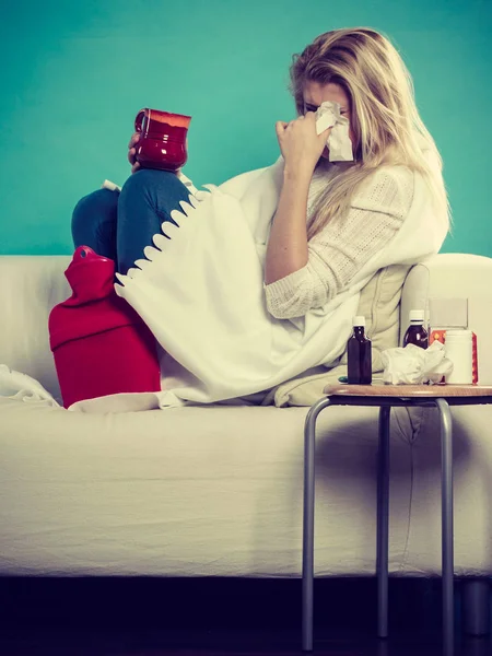 Mujer enferma teniendo gripe acostada en un sofá —  Fotos de Stock