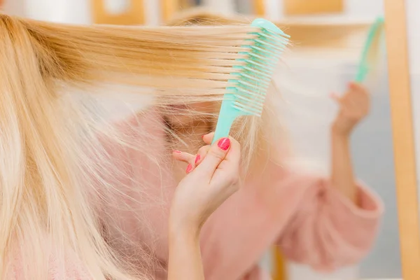 Mujer vestida con bata cepillándose el pelo — Foto de Stock