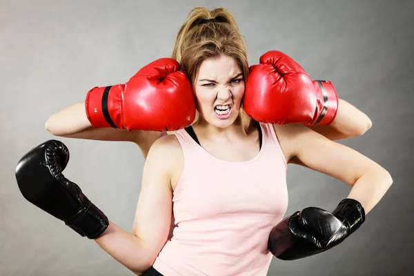 Woman having head between boxing gloves — Stock Photo, Image