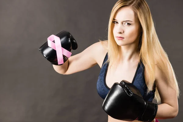 Woman wearing boxing gloves having pink ribbon — Stock Photo, Image