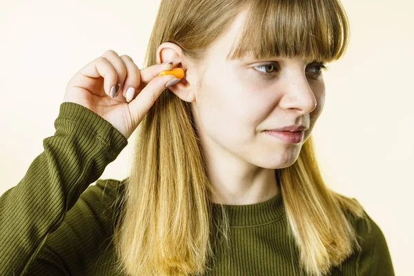 Mujer poniendo tapones en los oídos —  Fotos de Stock