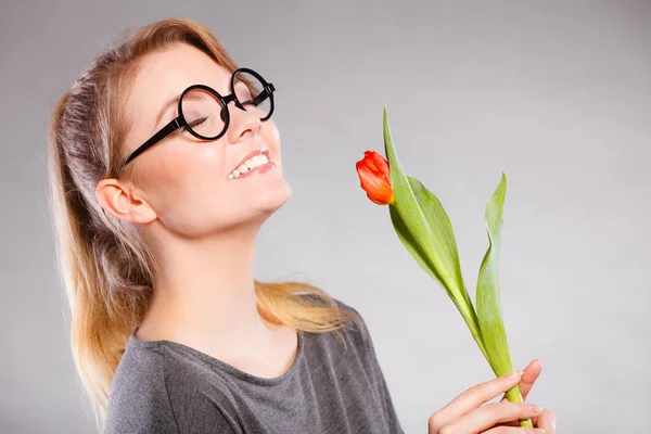 Sorrindo senhora cheirando flor . — Fotografia de Stock