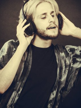 Sarışın adam kulaklıklar giyen stüdyoda şarkı