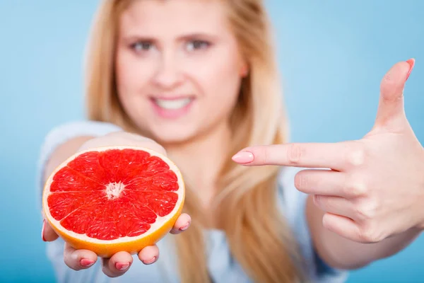 Женщина держит в руках цитрусовые грейпфруты — стоковое фото