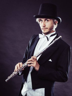 Zarif giyimli müzisyen flüt tutan