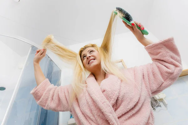Kvinna iklädd morgonrock borsta håret — Stockfoto