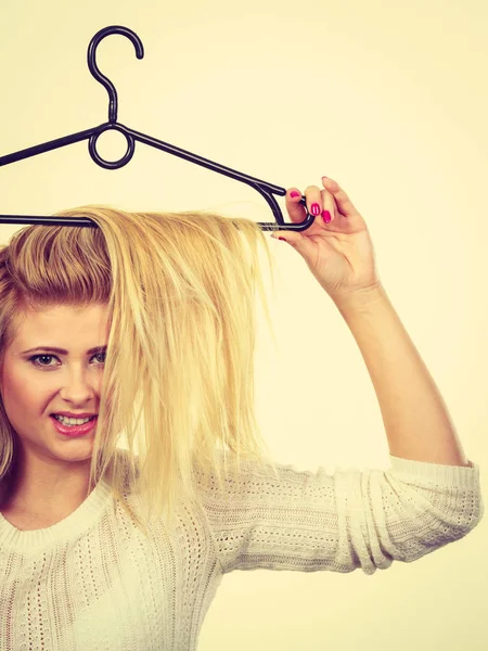 Mulher segurando o cabelo no cabide de roupas — Fotografia de Stock