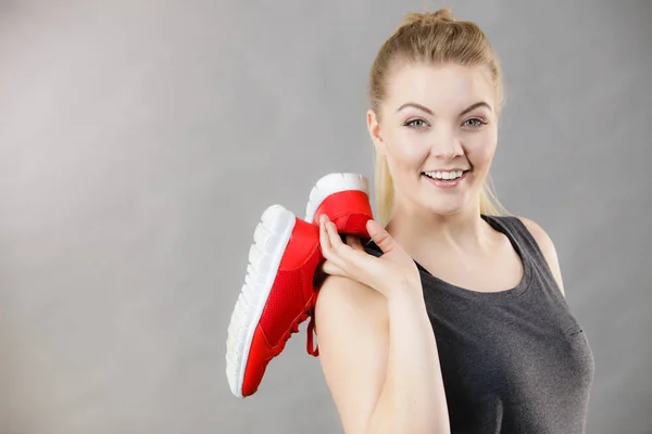 Mujer feliz presentando zapatillas deportivas zapatillas —  Fotos de Stock