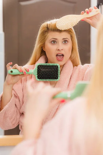 Mulher chocada usando vestido de vestir escovando o cabelo — Fotografia de Stock