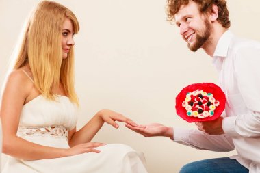 Kadın şeker demet çiçek veren adam. Mutlu çift