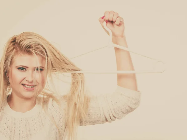 Woman holding hair on clothes hanger — Stock Photo, Image