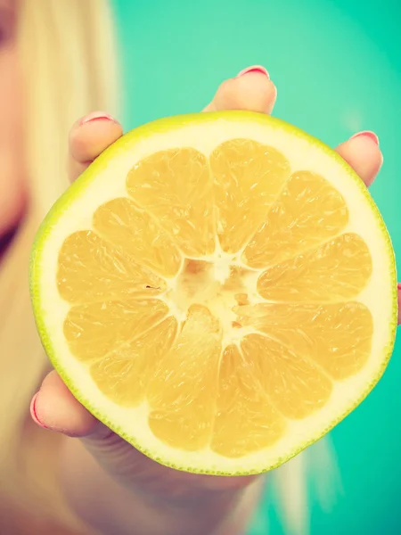 De helft van de gele grapefruit citrusvruchten in menselijke hand — Stockfoto