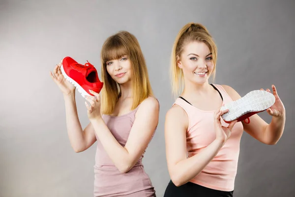 İki kadın spor giyim eğitmenler ayakkabı sunulması — Stok fotoğraf