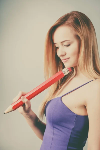 Woman confused thinking, big pencil in hand — Stock Photo, Image
