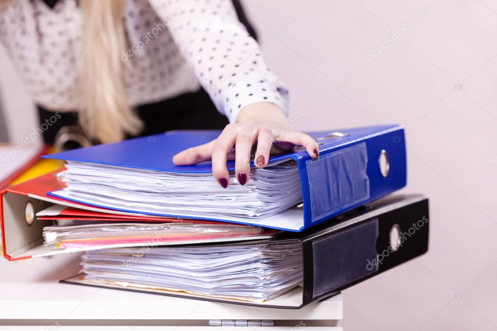 Many colorful binders with documents inside