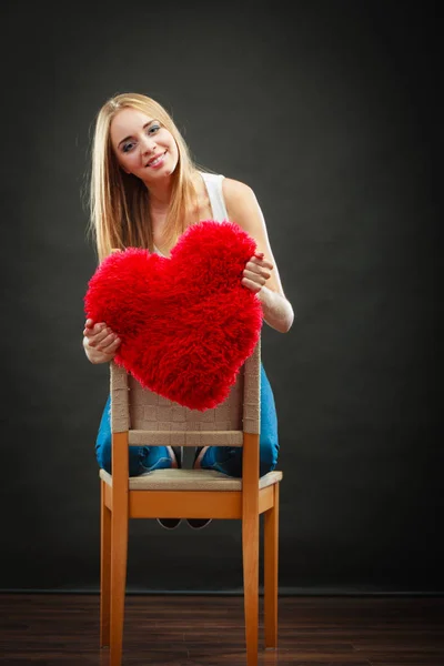 Wanita memegang hati berbentuk bantal simbol cinta — Stok Foto