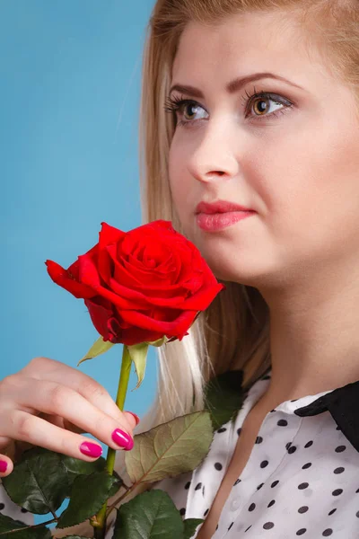 Frau mit roter Rose auf blauem Grund — Stockfoto