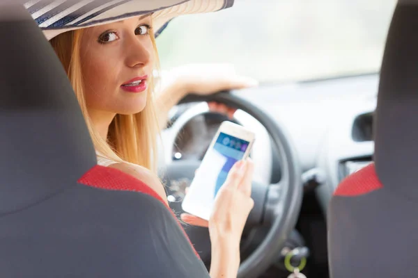 Frau benutzt Handy am Steuer ihres Autos — Stockfoto