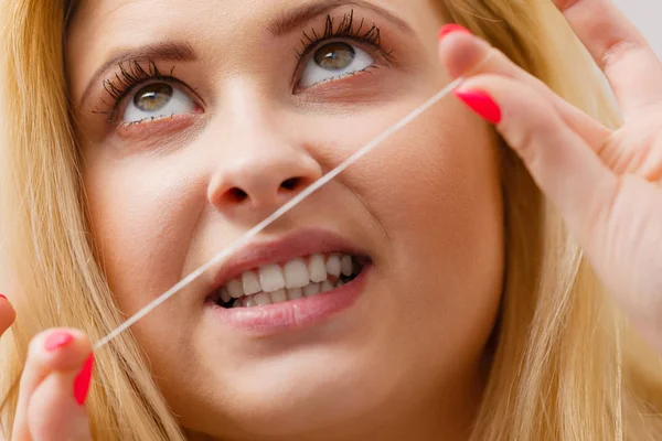 Femme se nettoie les dents à l'aide de fil dentaire — Photo