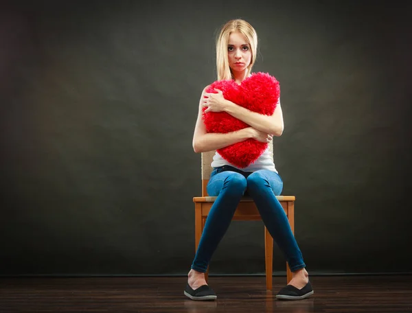Kırmızı kalp yastık tutan mutsuz mutsuz kadın — Stok fotoğraf