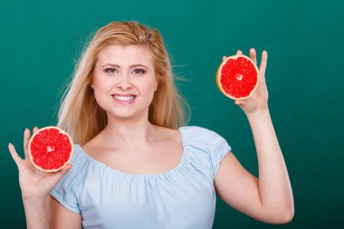 Kırmızı greyfurt tutan mutlu gülümseyen kadın