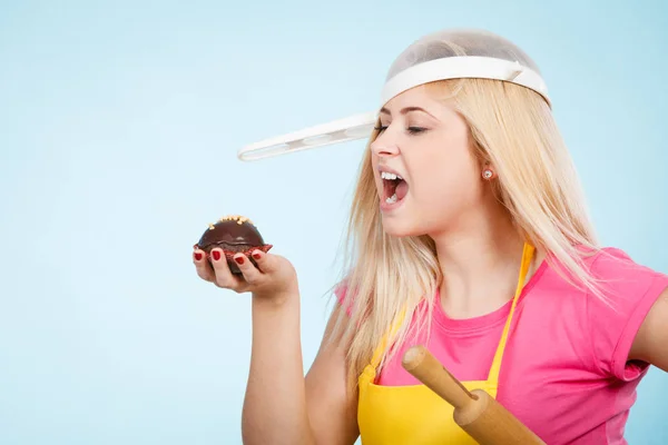 Mulher segurando cupcake vestindo escorredor na cabeça — Fotografia de Stock