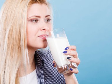 Kadın bardaktan süt içiyor.