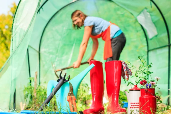 Perempuan petani dan alat berkebun di kebun — Stok Foto