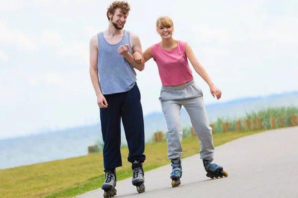 Homem encoraja mulher a fazer patins — Fotografia de Stock