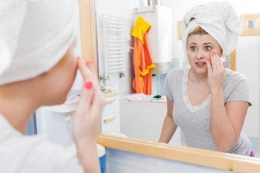 Bir kadın aynadaki yansımasına bakıyor.