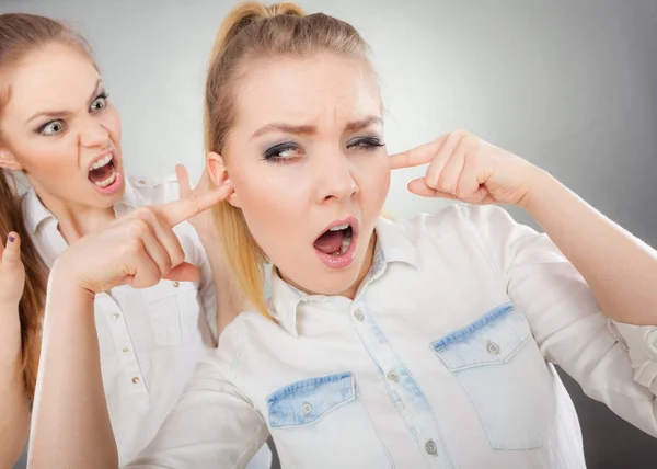 Fúria menina gritando com seu amigo, fêmea fechando seus ouvidos — Fotografia de Stock
