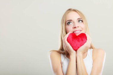 Gülümseyen kadın holding kırmızı kalp aşk sembolü