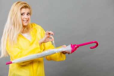 Kadın giyiyor yağmurluk kapanış şemsiye